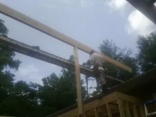Carpenter setting a ridge beam over a new addition frame — Ice Dam Removal by Roofing Brothers in Port Norris