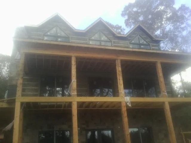 Dormers and porch framing on a large log home under construction — Roof Coating work by our crew in Port Norris