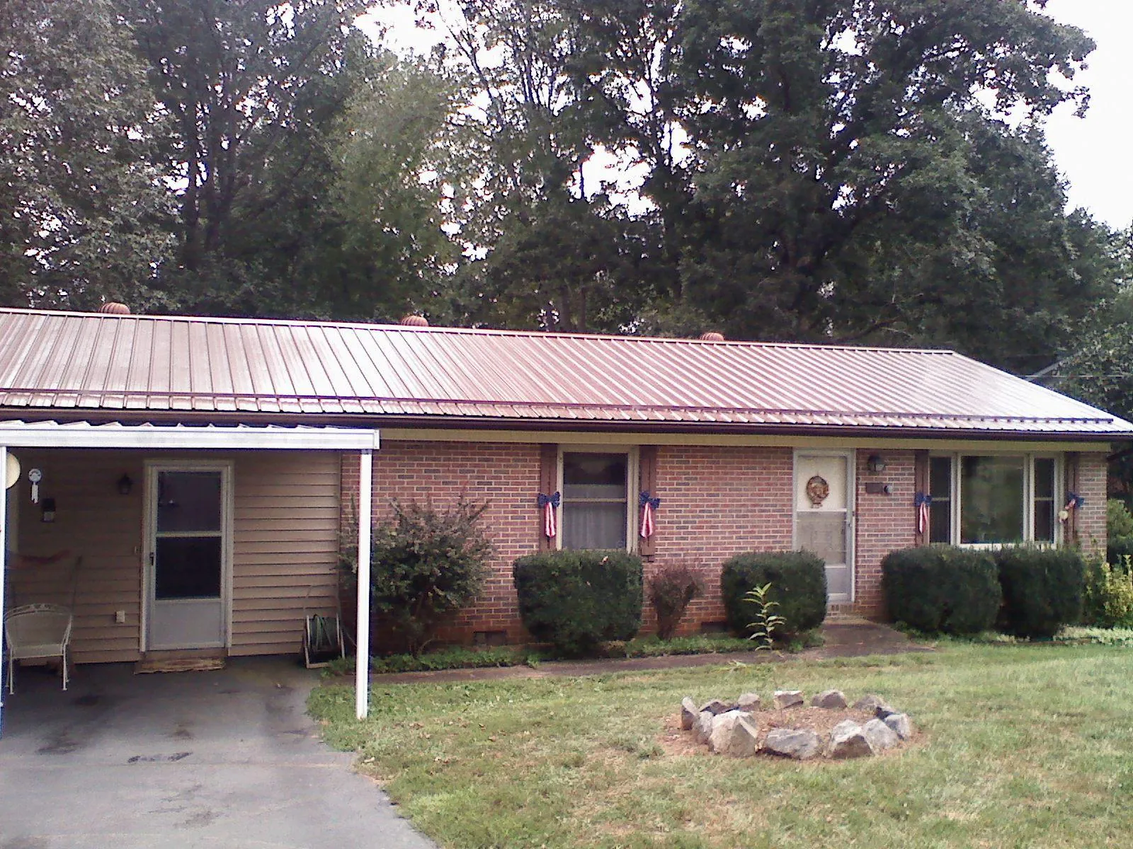 Bronze metal roof and carport on a brick ranch home — Roof Repair work by our crew in Port Norris